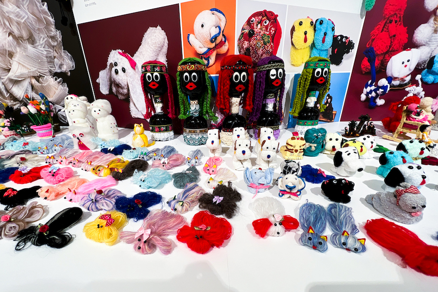 毛糸の犬に、タオルの犬、ボトル人形など。展示台いっぱいに作品が並びます。　photo by ぷらいまり