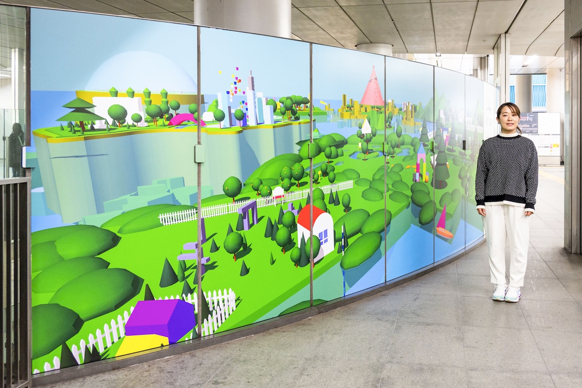 リアルスペースプロジェクト第一弾の作品と アーティスト原田郁さん　　仮想空間の理想郷が色鮮やかな3Dモデルで描かれています。（写真撮影：ぷらいまり）