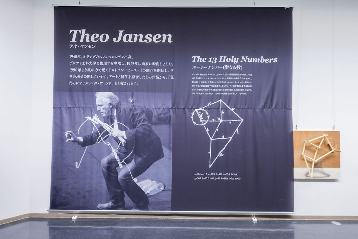 テオ・ヤンセン氏の写真と、「ホーリーナンバー（聖なる数）」を使った機構の模型（写真撮影：ぷらいまり）